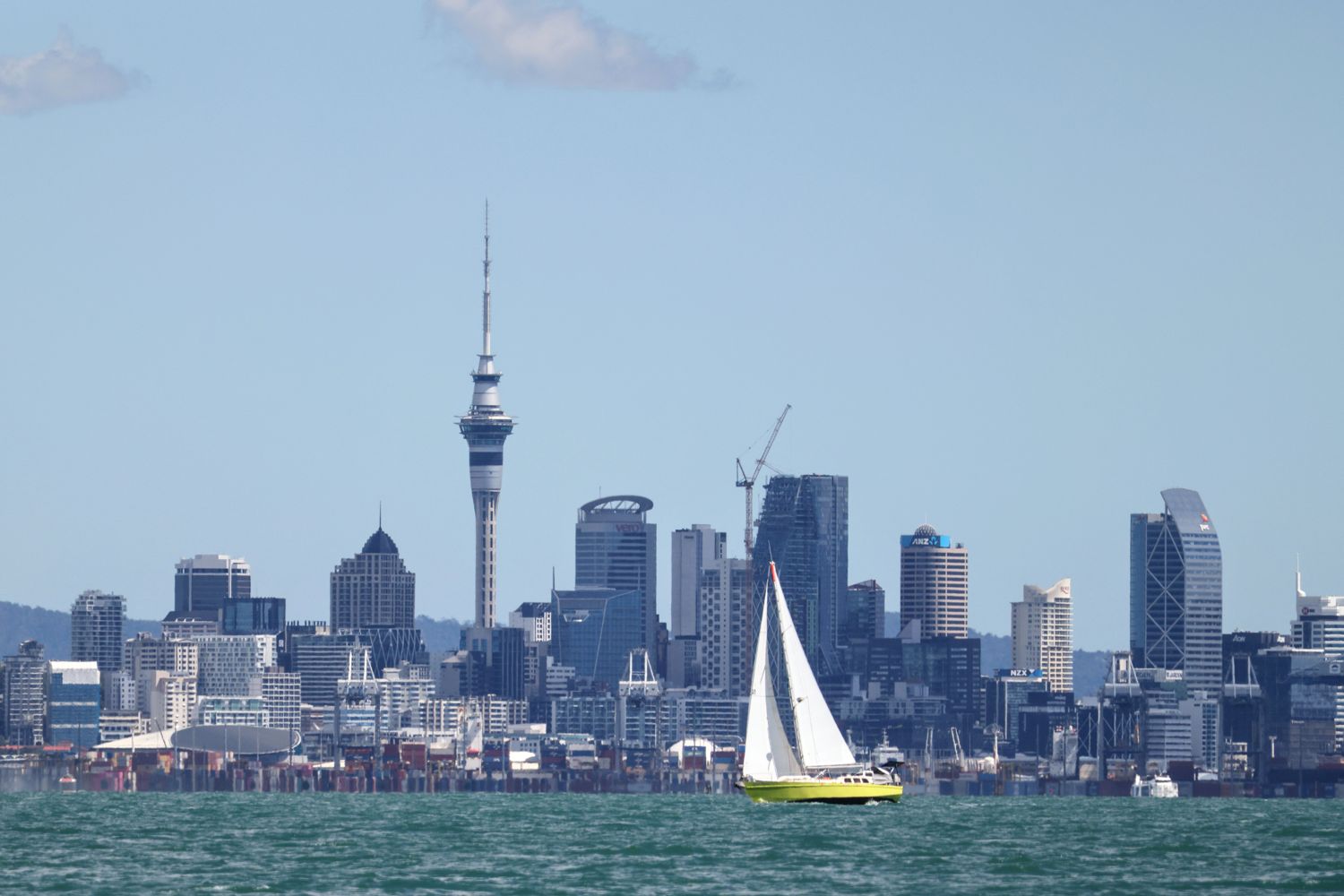 The Auckland skyline and Sky Tower across the harbour, with a sailing yacht