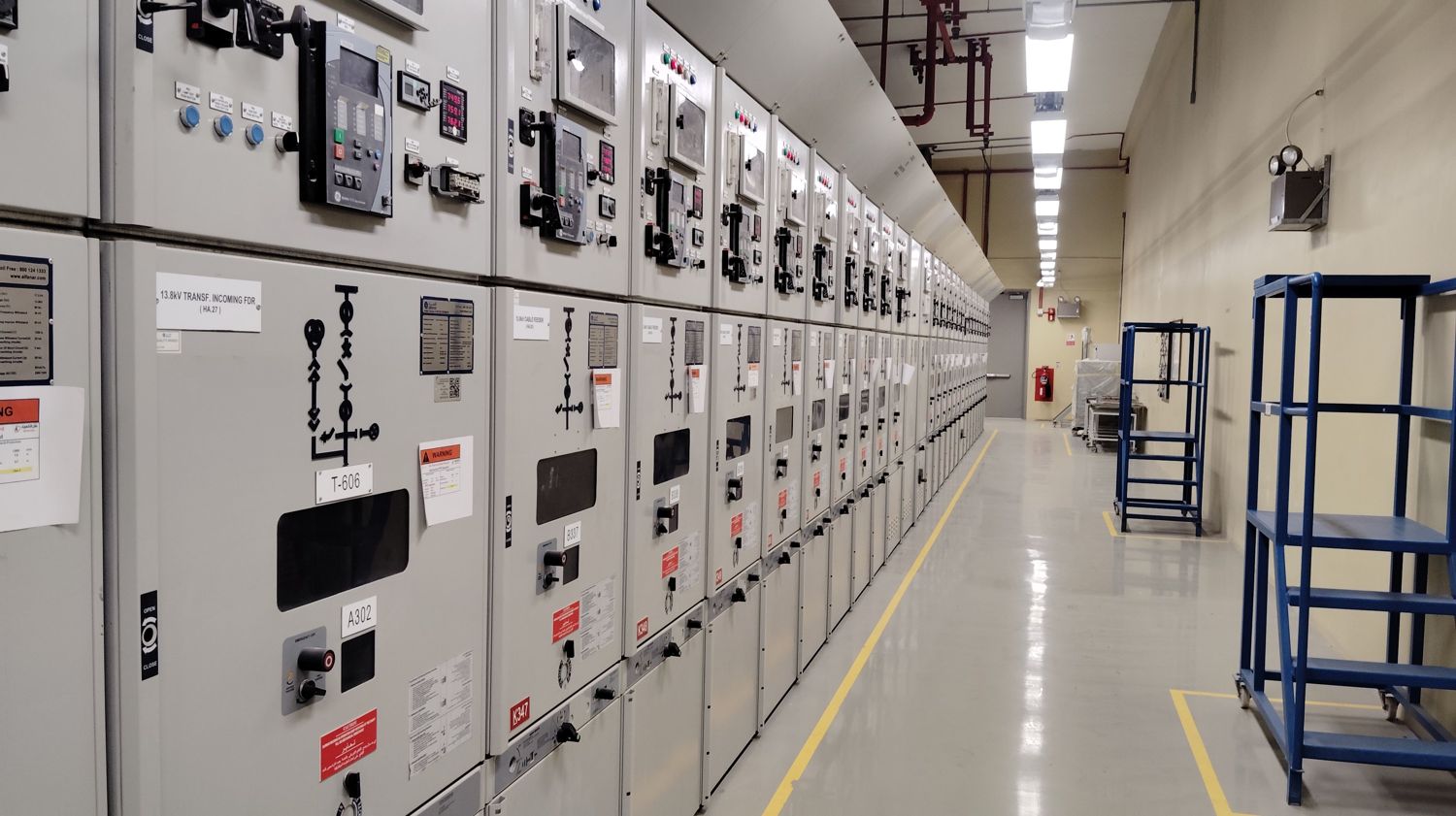A long row of low-voltage switchgear cabinets in an electrical room