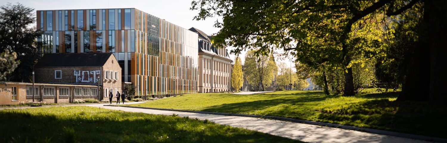 A modern university building beside a landscaped path