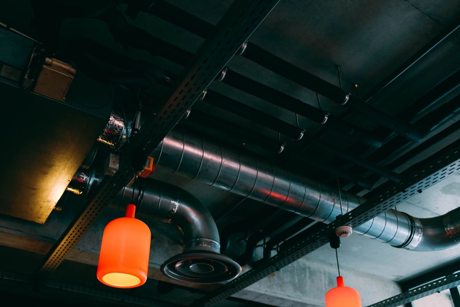 Ductwork, cable tray and pendant luminaires above a ceiling