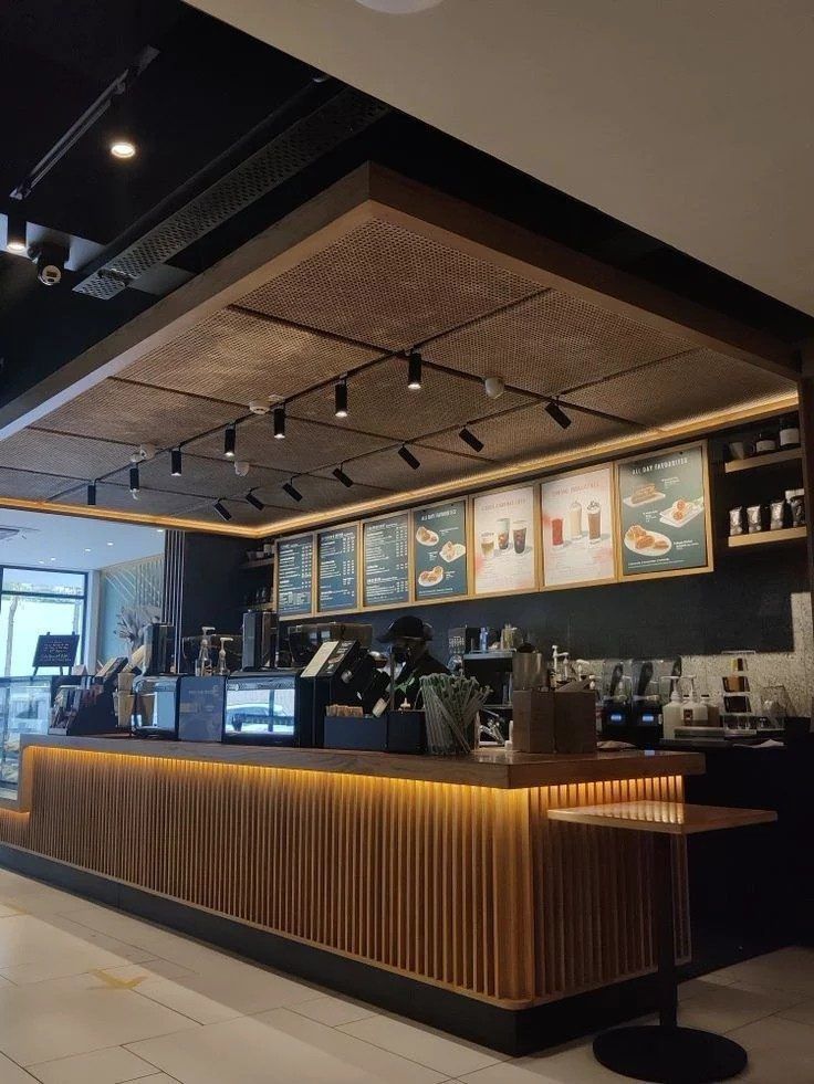 A cafe counter with menu boards and timber slat cladding
