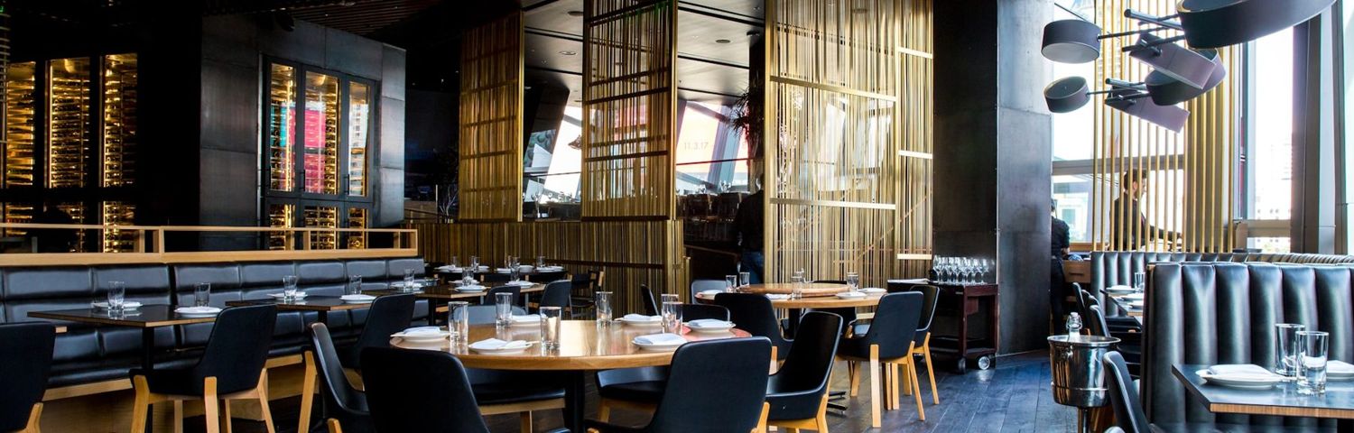An upscale restaurant dining room with booth seating