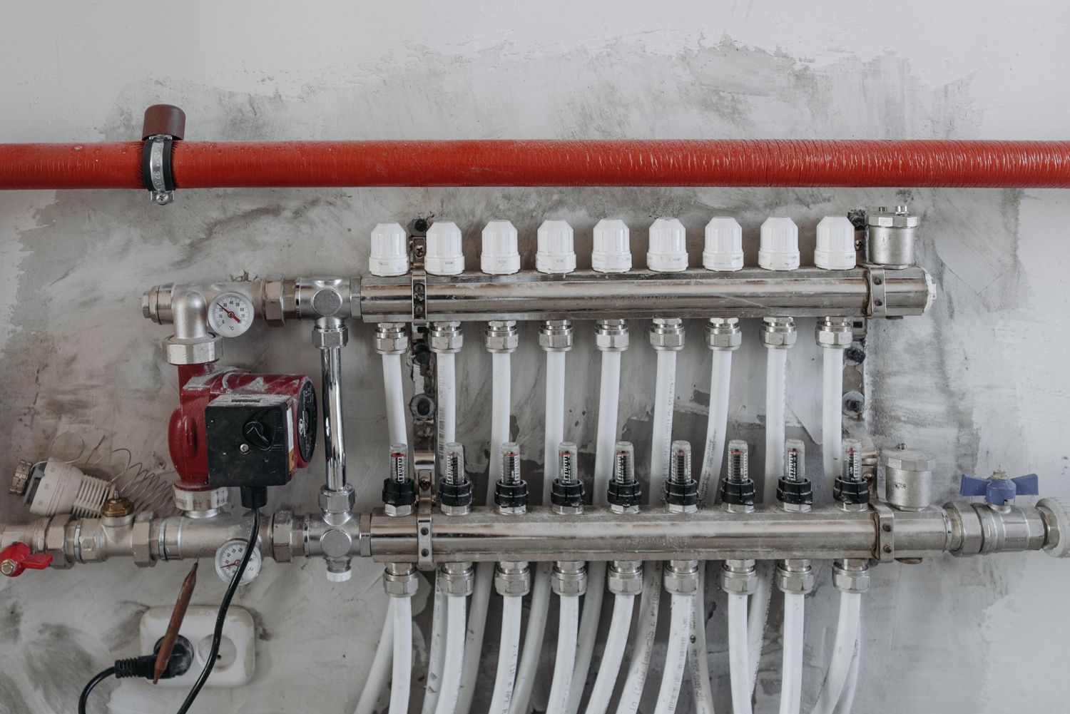 A heating and water manifold on a plant-room wall